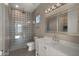 Modern bathroom with patterned shower, white vanity, and large mirror at 744 E Desert Ln, Phoenix, AZ 85042