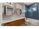 Bathroom with double vanity, blue tile shower, and large mirrors at 744 E Desert Ln, Phoenix, AZ 85042