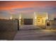 Stunning desert sunset view of a contemporary home with gated entry at 744 E Desert Ln, Phoenix, AZ 85042