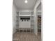 White built-in pantry with wooden bench and shelving at 744 E Desert Ln, Phoenix, AZ 85042