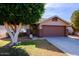 Front yard view of a single-story house with a large tree and a well-maintained lawn at 8605 W Paradise Dr, Peoria, AZ 85345