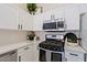 Modern kitchen with white cabinets, stainless steel appliances, and quartz countertops at 8605 W Paradise Dr, Peoria, AZ 85345