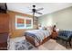 Bedroom with striped bedding, ceiling fan, and adjacent sitting area at 9101 W Willow Haven Ct, Sun City, AZ 85351