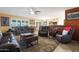 Spacious living room with leather furniture and a ceiling fan at 9101 W Willow Haven Ct, Sun City, AZ 85351