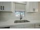 Clean kitchen with white cabinets, a stainless steel sink, and modern faucet at 9144 E Balsam Ave, Mesa, AZ 85208