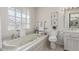 Elegant bathroom with a soaking tub, toilet and large vanity at 11009 W Crestbrook Dr, Sun City, AZ 85351