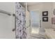 Accessible bathroom with shower, grab bars, and floral shower curtain at 11009 W Crestbrook Dr, Sun City, AZ 85351