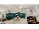 Living room with teal sectional sofa and large windows at 11009 W Crestbrook Dr, Sun City, AZ 85351