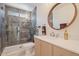 Stylish bathroom featuring a glass shower, round mirror, and modern vanity at 11802 S Half Moon Dr, Phoenix, AZ 85044