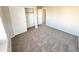 Well-lit bedroom with neutral walls, carpet flooring, and a closet at 12367 W Woodland Ave, Avondale, AZ 85323