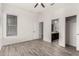 Bright bedroom with wood-look tile flooring, ceiling fan, and private bathroom access at 12808 N 144Th Dr, Surprise, AZ 85379