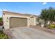 Exterior of home with three-car garage, well-maintained lawn, and mature trees at 1364 E Elysian Pass, Queen Creek, AZ 85140