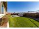 Landscaped backyard with artificial turf, seating area, and modern fire pit at 13713 W Harvest Ave, Litchfield Park, AZ 85340