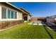 Modern backyard with artificial turf and a sitting area next to the house at 13713 W Harvest Ave, Litchfield Park, AZ 85340