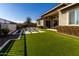 Modern backyard with artificial turf and a sitting area next to the house at 13713 W Harvest Ave, Litchfield Park, AZ 85340