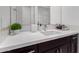 Modern bathroom vanity with white countertop, dark brown cabinets, and stylish fixtures at 13713 W Harvest Ave, Litchfield Park, AZ 85340