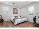 Bright bedroom with a gray upholstered bed and a workspace at 13713 W Harvest Ave, Litchfield Park, AZ 85340