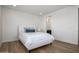 Light-filled bedroom with a white upholstered bed and ensuite bathroom at 13713 W Harvest Ave, Litchfield Park, AZ 85340