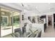 Modern dining room with glass table and chairs, and view of backyard at 13713 W Harvest Ave, Litchfield Park, AZ 85340