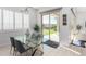 Modern dining area with glass table, gray chairs, and backyard access at 13713 W Harvest Ave, Litchfield Park, AZ 85340