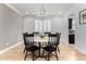 Bright dining room features a round table with black chairs and a modern chandelier at 13713 W Harvest Ave, Litchfield Park, AZ 85340