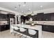 Modern kitchen with dark cabinets and a large island at 13713 W Harvest Ave, Litchfield Park, AZ 85340