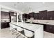 Modern kitchen with dark cabinetry, white countertops, and stainless steel appliances at 13713 W Harvest Ave, Litchfield Park, AZ 85340