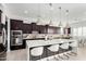 Modern kitchen with dark cabinetry, white countertops, and stainless steel appliances at 13713 W Harvest Ave, Litchfield Park, AZ 85340