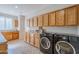 Laundry room with washer, dryer, and oak cabinets at 1572 E Artemis Trl, Queen Creek, AZ 85140