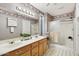 Bathroom with double vanity, shower, and floral wallpaper at 20947 N 107Th Dr, Peoria, AZ 85373