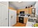 Galley kitchen with wood cabinets, gas range, and refrigerator at 20947 N 107Th Dr, Peoria, AZ 85373