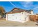 View of a two-car garage with a wooden gate nearby the structure at 21063 N 33Rd Ln, Phoenix, AZ 85027