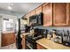 Kitchen showcasing dark wood cabinetry, black appliances, and laminate countertops at 21063 N 33Rd Ln, Phoenix, AZ 85027