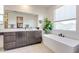 Modern bathroom with soaking tub, double vanity, and large mirror at 21632 W Hillcrest Blvd, Buckeye, AZ 85396