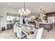 Elegant dining room with a spacious table, modern chandelier, and open floor plan at 21632 W Hillcrest Blvd, Buckeye, AZ 85396