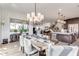 Bright dining room features a large table, chandelier, and view into the kitchen at 21632 W Hillcrest Blvd, Buckeye, AZ 85396