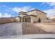 Modern two story home with stone and neutral colors, a three car garage, and a landscaped yard at 21632 W Hillcrest Blvd, Buckeye, AZ 85396