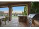 Outdoor kitchen and patio overlooking a putting green and sparkling pool at 23861 N 74Th Pl, Scottsdale, AZ 85255