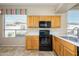 Kitchen with wood cabinets, black appliances, and window at 23901 S Vacation Way, Sun Lakes, AZ 85248