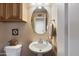 Clean bathroom with pedestal sink and oval mirror at 2509 W Straight Arrow Ln, Phoenix, AZ 85085