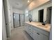 Modern bathroom featuring dual sink vanity, framed mirrors, and separate glass shower at 25318 W Bowker St, Buckeye, AZ 85326