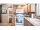 White stove and microwave with wood cabinets and tile backsplash at 288 Diamond Dr, Apache Junction, AZ 85119