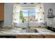 Kitchen sink with granite countertop and window overlooking backyard at 3448 W Sunshine Butte Dr, San Tan Valley, AZ 85144