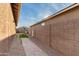 Landscaped backyard with pathway, block wall, and exterior AC unit at 35350 W Marin Ave, Maricopa, AZ 85138