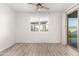 Bright bedroom with wood-look floors and sliding door to backyard at 35350 W Marin Ave, Maricopa, AZ 85138