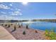 Scenic view of a pond with fountains, a walking path, and lush landscaping under a clear blue sky at 35350 W Marin Ave, Maricopa, AZ 85138