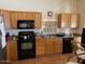 Kitchen with oak cabinets, black appliances, and tile floor at 355 E 13Th Ave, Apache Junction, AZ 85119