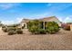 Backyard with covered patio, desert landscaping, and citrus trees at 3677 N Hudson Dr, Florence, AZ 85132