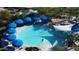 Aerial view of a circular pool with blue umbrellas and surrounding lounge chairs at 3677 N Hudson Dr, Florence, AZ 85132