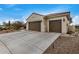 Two-car garage with a long driveway and desert landscaping at 3677 N Hudson Dr, Florence, AZ 85132